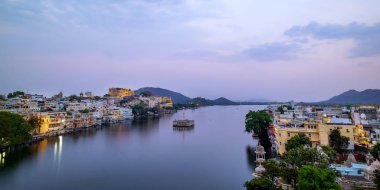 Udaipur şehri, Pichola Gölü, Rajasthan, Hindistan. Şehir sarayının manzarası göle yansıyor.