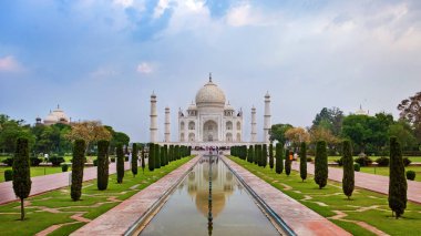 Taj Mahal 'in ön görüntüsü yansıma havuzuna yansıdı, Uttar Pradesh, Hindistan' daki Yamuna nehrinin güney kıyısındaki fildişi beyazı mermer mozoleye. Dünyanın yedi harikasından biri..