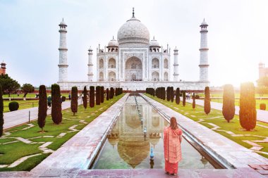 Ne zaman güneş doğuyor, Agra, Yamuna Nehri'nin güney yakasında bir Fildişi-beyaz mermer Türbesi Taj Mahal bir kadın ayakta ön Uttar Pradesh, Hindistan. 