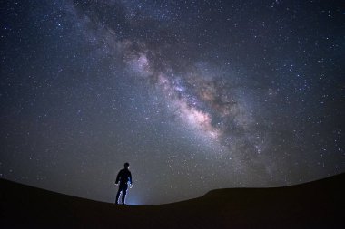 Samanyolu galaksisinin bir adamla ayakta ve Tar çöl, Jaisalmer, Hindistan izliyor. Astro fotoğraf.