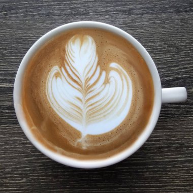 Bir fincan kahve latte sanat üstten görünüm ahşap arka plan üzerinde.