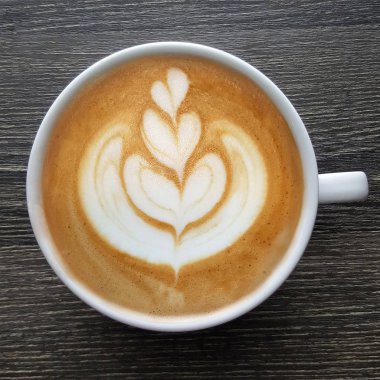 Bir fincan kahve latte sanat üstten görünüm ahşap arka plan üzerinde.