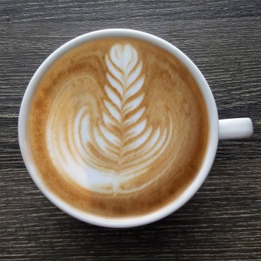 Bir fincan kahve latte sanat üstten görünüm ahşap arka plan üzerinde.