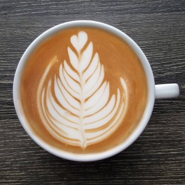 Bir fincan kahve latte sanat üstten görünüm ahşap arka plan üzerinde.