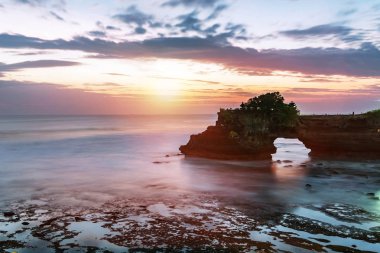 Günbatımı Bali Adası - Tanah çok ve Batu Bolong Tapınağı'nın ünlü turistik landmark yakınındaki. Uzun pozlama etkisi, Bali Endonezya. Endonezya, Bali tropikal doğa manzara.
