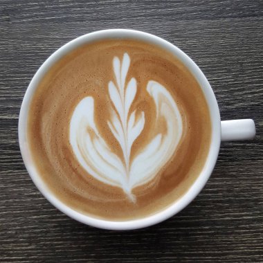 Bir fincan kahve latte sanat üstten görünüm ahşap arka plan üzerinde.