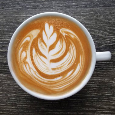 Bir fincan kahve latte sanat üstten görünüm ahşap arka plan üzerinde.