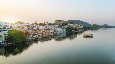 Udaipur şehri sabah Pichola Gölü 'nde, Rajasthan, Hindistan. Şehir sarayının manzarası göle yansıyor.