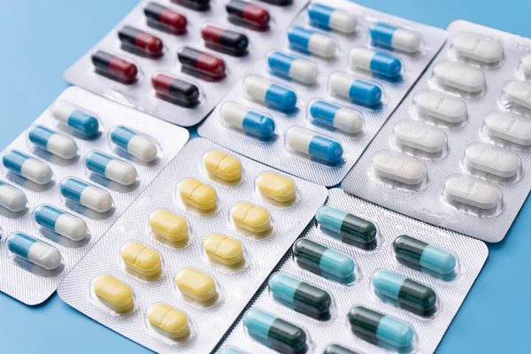 Mavi arka planda ilaç hapları. Çeşitli ilaçlar için metin kopyalama alanı. Sağlıklı beslenme, yaşam tarzı.