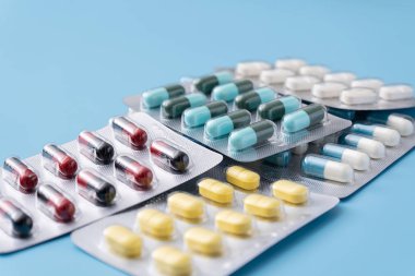 Mavi arka planda ilaç hapları. Çeşitli ilaçlar için metin kopyalama alanı. Sağlıklı beslenme, yaşam tarzı.