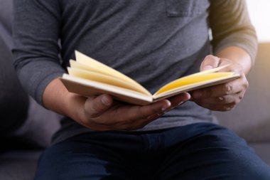 bir kitap okuma ve fincan kahve oturmak okunur bilgi tutan adam