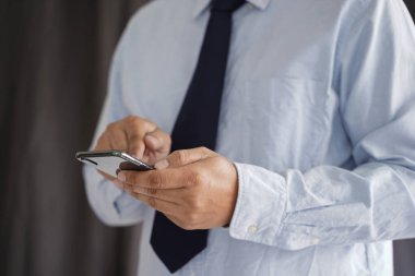 İş adamı tutmak belgili tanımlık smartphone üzerinde street ve kopya alanı.
