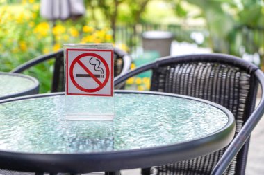 Bir kafe ve park içinde hiç Sigara İçilmez işareti