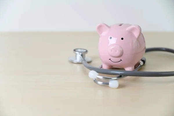 Stetoskop mali checkup veya med için tasarruf ile Piggy banka — Stok fotoğraf