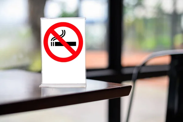 no smoking sign with shopping place background on wooden table