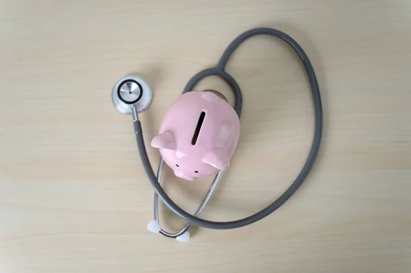 Piggy bank with stethoscope  financial checkup or saving for med