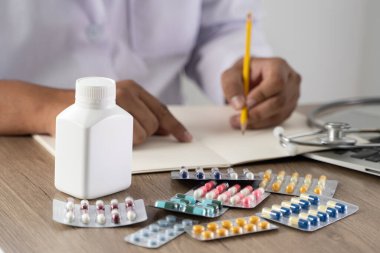 Tıp doktoru steteskoplu reçeteli doktor yazıyor.