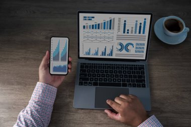 Bilgisayarda ve akıllı telefonda analitik çizelgeleri gösteren iş verileri konsepti. Finans, pazarlama ve performans izleme grafikleriyle profesyonel çalışma alanı.