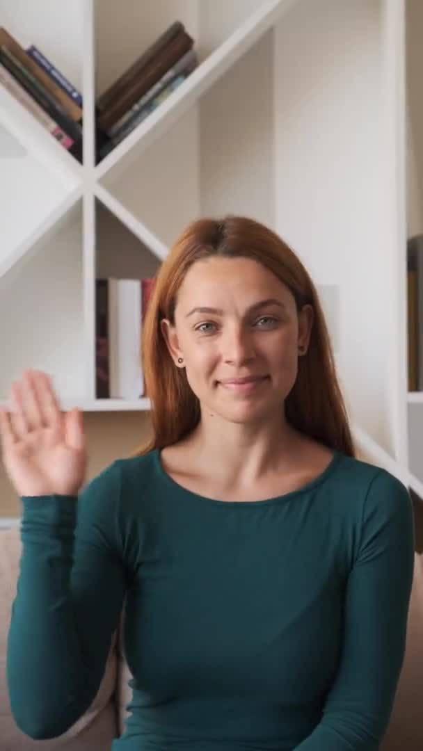 Bela jovem mulher ter vídeo chat usando webcam em casa acenando mão compartilhando estilo de vida gostando de conversar comunicação on-line na tela vertical — Vídeo de Stock