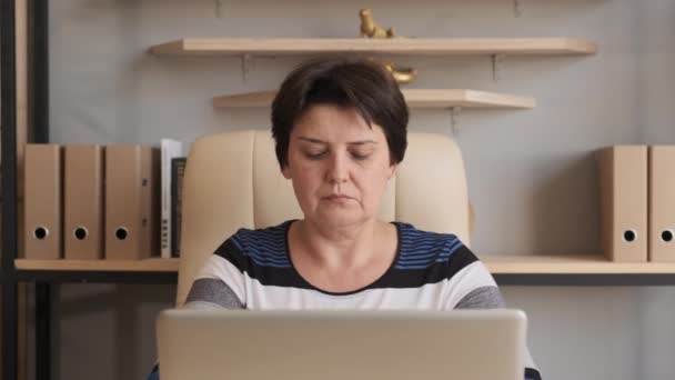 Mujer trabajando en un ordenador portátil. Haciendo trabajo en línea en casa — Vídeos de Stock