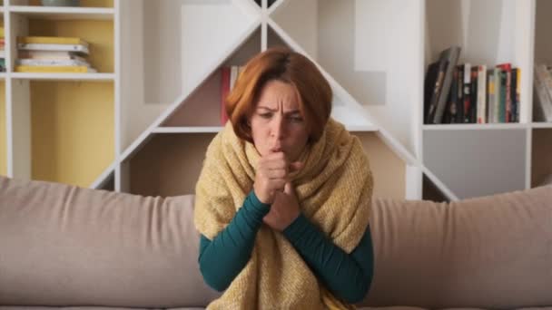 Kobieta marznie w domu. chora dziewczyna z gorączką objawy grypy grypa temperatury zawinięte w koc drżący wewnątrz. — Wideo stockowe