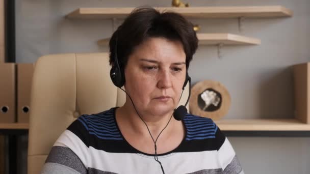 Le casque d'écoute de femme communiquant par conférence téléphonique parle regardant l'ordinateur au bureau à la maison, entretien d'emploi de chat vidéo ou cours de langue à distance avec le concept de professeur en ligne — Video