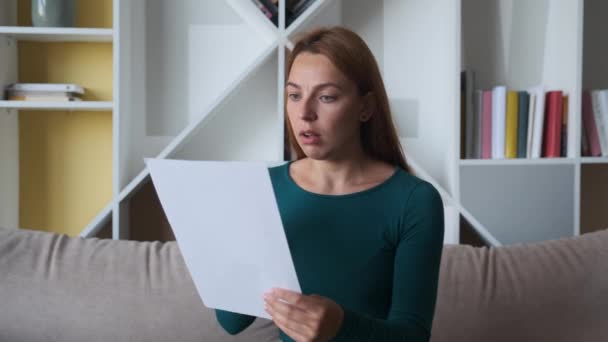 Smutná žena sedí na gauči doma čte obdržela špatné zprávy drží dokumenty papírový dopis cítí zoufalý o finančních problémech, dívka student strach vysoká škola vyhoštění koncept. — Stock video