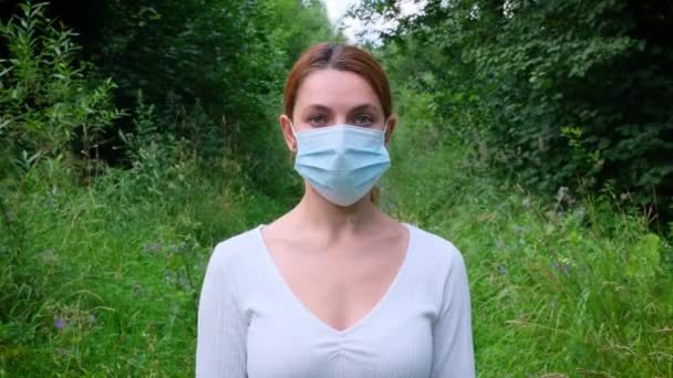 Pandémico, retrato de una joven con máscara protectora en el parque. covid concept health and safety, N1H1 coronavirus quarantine, virus protection — Vídeo de stock
