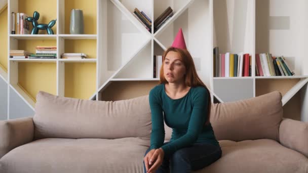 Traurige junge Frau feiert Geburtstag allein im Wohnzimmer. — Stockvideo