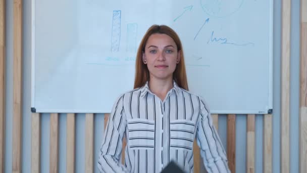 Mooi glimlachen vertrouwen jonge vrouw mooi gezicht kijken naar camera poseren alleen in kantoor — Stockvideo