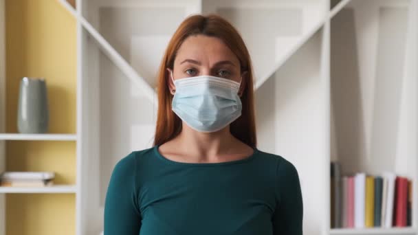 Porträtt av en ung kvinna med mask i hemmet.Begreppet hälsa och säkerhet liv, N1H1 coronavirus, virusskydd, pandemi i Kina — Stockvideo
