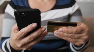 Kredi kartı ve akıllı telefonu olan müşteriyi kapat. Çevrimiçi dükkanda hızlı ve kolay ödemeler yapan bir bayan müşteri. E-bankacılık uygulama servisi