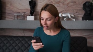 Akıllı telefona bakan şaşırmış kadın suratı. Akıllı telefondan internet haberlerini izleyen iş kadınlarını kapatın. Akıllı telefondaki mutlu kız alışveriş sitesinin portresi