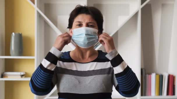 Porträt einer jungen Frau mit Maske zu Hause. Gesundheits- und Sicherheitskonzept, Coronavirus N1H1, Virenschutz, Pandemie in China — Stockvideo