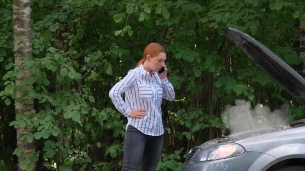 Jeune femme sur la route de campagne essayant d'obtenir de l'aide avec sa voiture en panne et appeler l'évacuation — Video