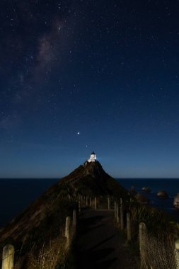 Nugget Point Deniz fenerinde yıldızlı bir gece. Yeni Zelanda, Samanyolu 'nun altında..
