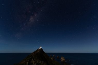 Nugget Point Deniz fenerinde yıldızlı bir gece. Yeni Zelanda, Samanyolu 'nun altında..