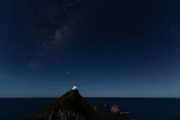 Nugget Point Deniz fenerinde yıldızlı bir gece. Yeni Zelanda, Samanyolu 'nun altında..