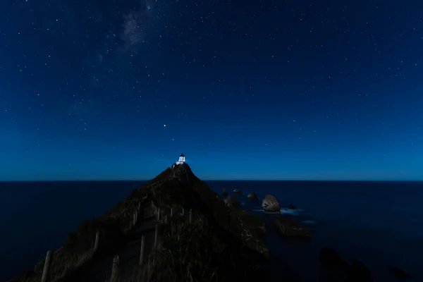 Nugget Point Deniz fenerinde yıldızlı bir gece. Yeni Zelanda, Samanyolu 'nun altında..
