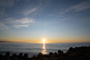 Yeni Zelanda 'nın Oamaru kentindeki kayalık şelaleye güzel bir manzara altın gün batımıyla.