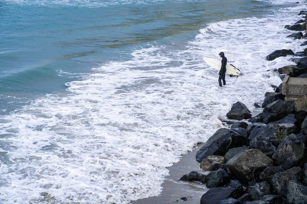 Surfer Wetsuit Met Surfplank Die Oceaangolven Zien Neerstorten Boven Rotsen — Stockfoto