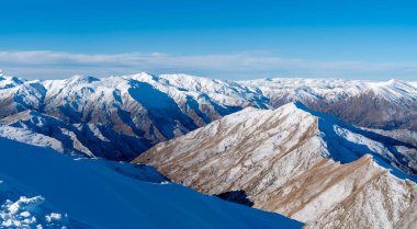 Güney Adası, Yeni Zelanda 'da kar dağlarının mavi gökyüzüne karşı kış manzarası.