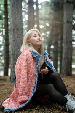 Güzel Asyalı kadın bir çam ormanının ortasında dinleniyor..