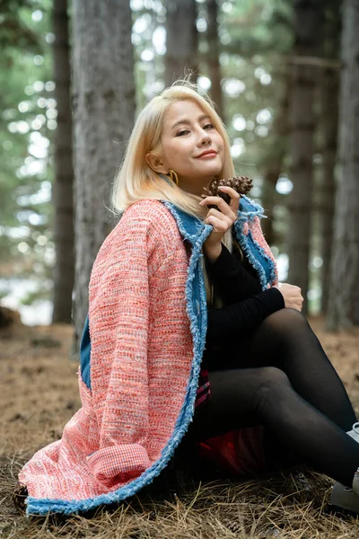 Güzel Asyalı kadın bir çam ormanının ortasında dinleniyor..