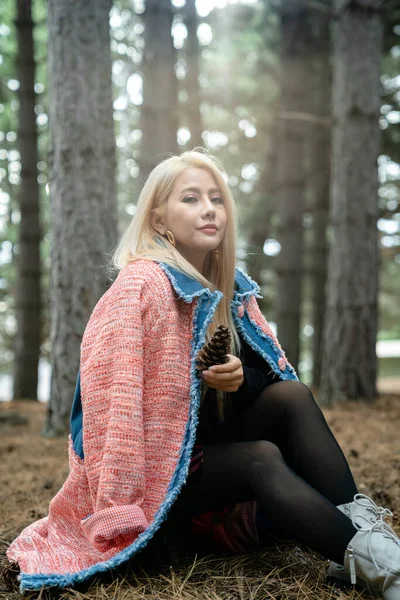 Güzel Asyalı kadın bir çam ormanının ortasında dinleniyor..