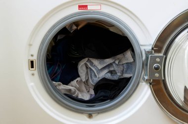 Çamaşır makinesi yıkanacak kıyafetlerle dolu.