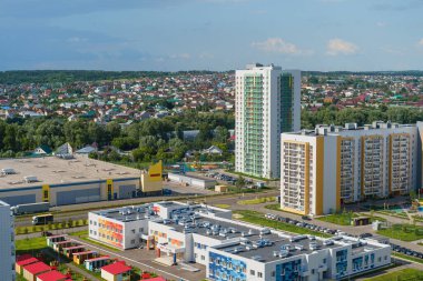 Hava manzaralı, kamu konutları HDB sakinleri, çimen bahçesi, ağaçlar, yaya yolu, gün batımında apartman yoğunluğu olan çok katlı yeni apartmanlar..