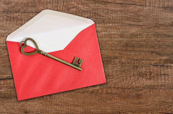 木质背景红色信封上的复古键 — 图库照片
