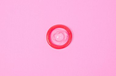 Haber ya da metin için boş alan ile pembe arka plan üzerinde pembe kondom.