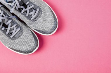 Pembe bir arka plan üzerinde gri kadın spor ayakkabı. Düz yatıyordu, en iyi görünüm çok az arka plan. Moda blog veya dergi kavramı.